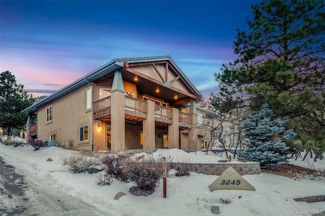 snow covered property with a balcony