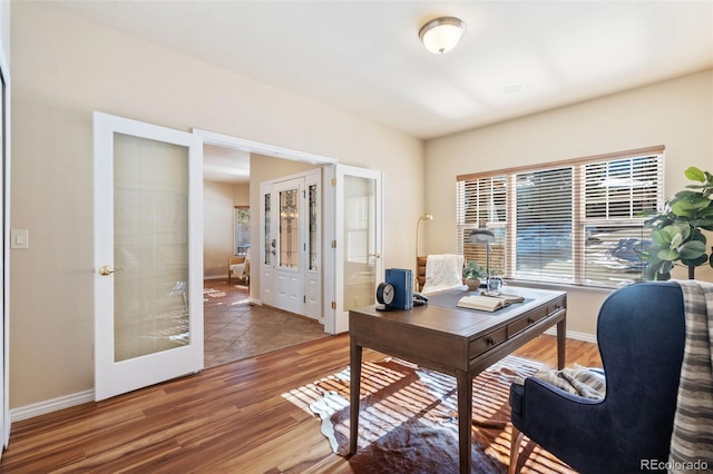 home office featuring hardwood / wood-style floors and french doors