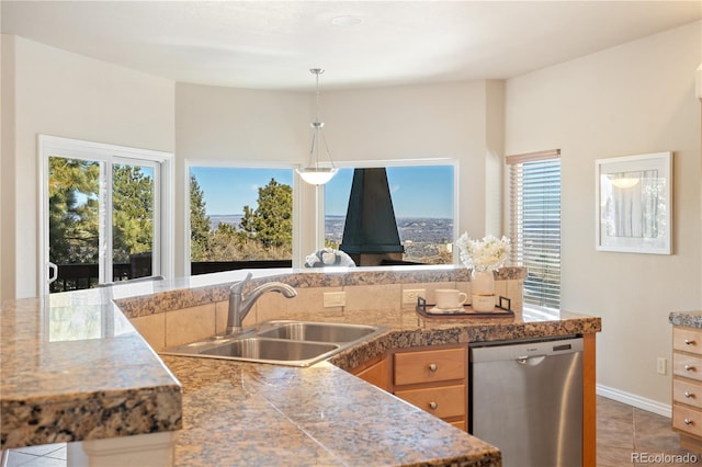 kitchen with pendant lighting, sink, stainless steel dishwasher, and light tile patterned floors