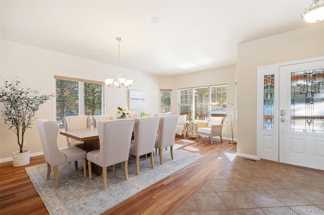 dining room with a notable chandelier, light hardwood / wood-style floors, and a wealth of natural light