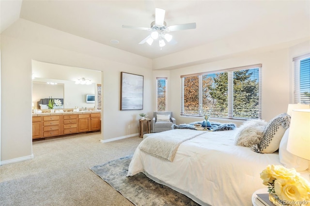 carpeted bedroom featuring ceiling fan, connected bathroom, and a raised ceiling