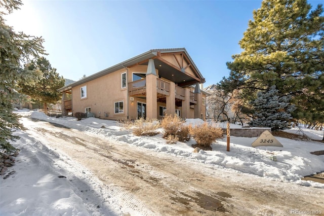 snow covered property with a balcony