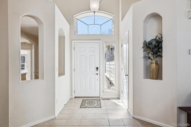 foyer featuring light tile patterned flooring and baseboards