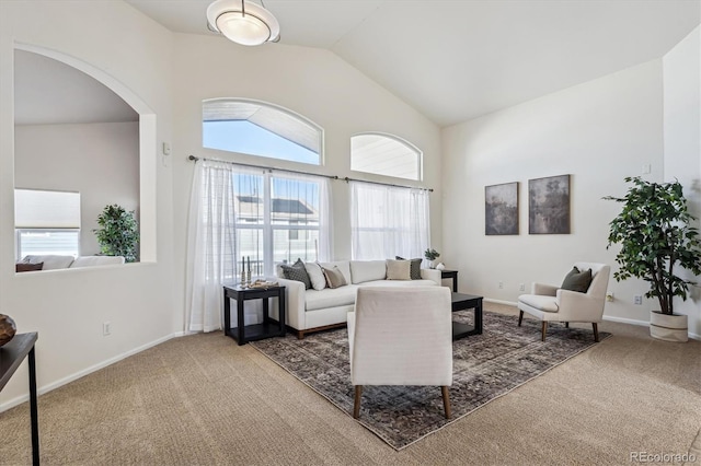 living room featuring carpet floors, arched walkways, and a healthy amount of sunlight