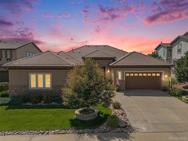 prairie-style house with a garage and a lawn