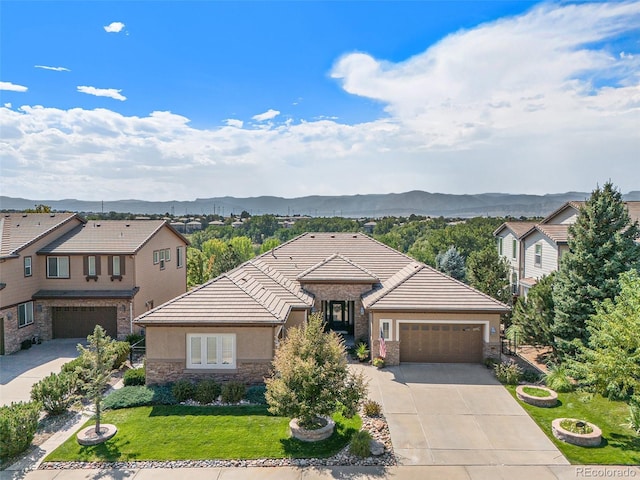 view of front of house with a mountain view, a garage, and a front lawn