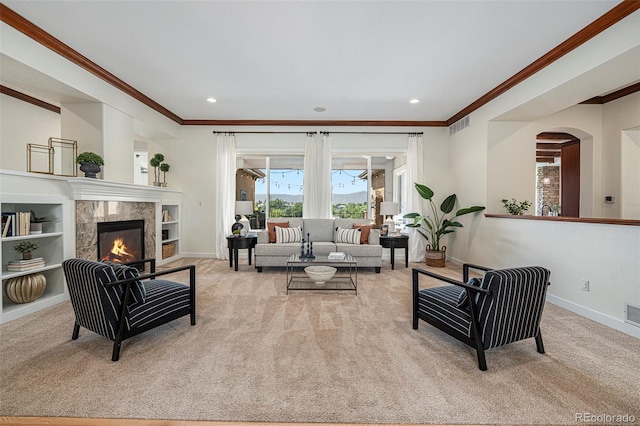 carpeted living room featuring ornamental molding, a fireplace, and built in shelves