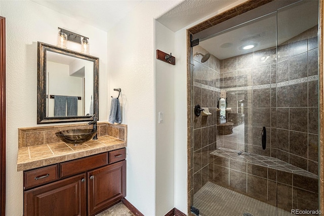 bathroom featuring vanity and a shower with door