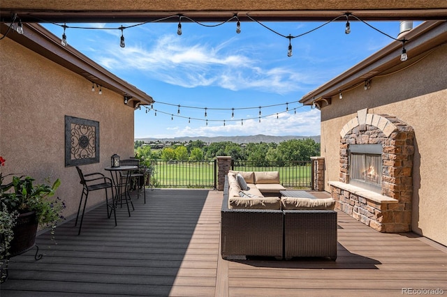 wooden deck featuring a mountain view and an outdoor living space with a fireplace