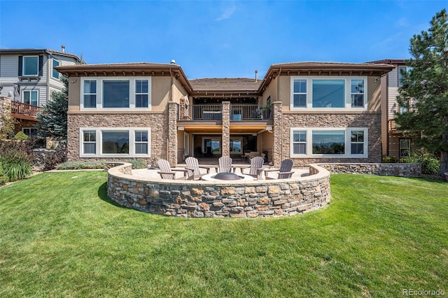 rear view of house featuring a patio area, a balcony, and a lawn