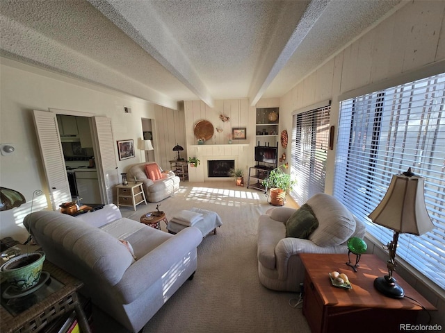 carpeted living room with a textured ceiling, beamed ceiling, wood walls, and a fireplace