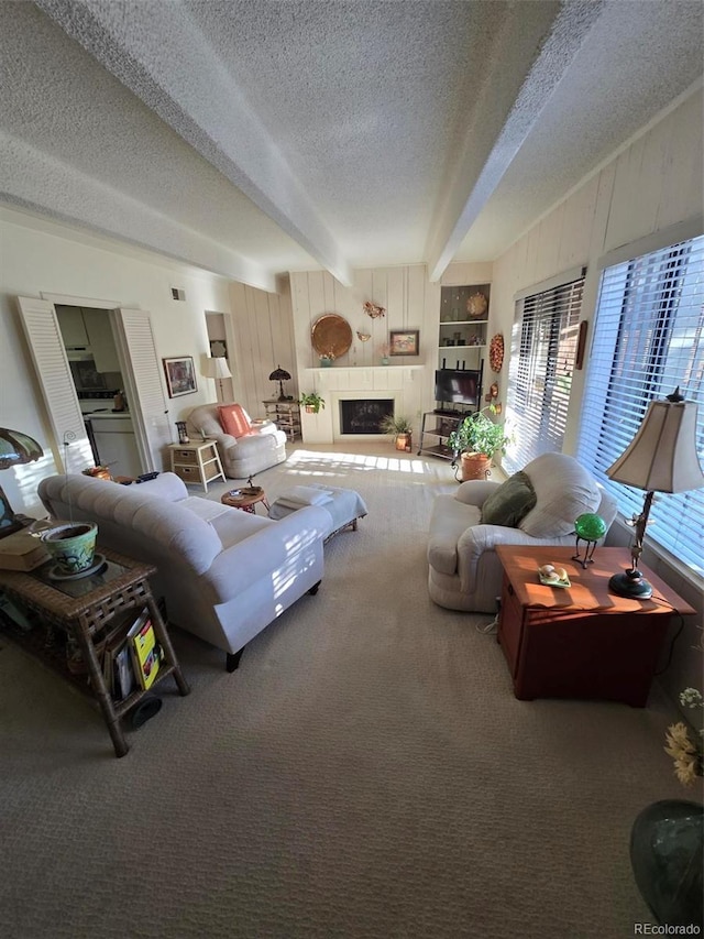 living room featuring carpet floors, a fireplace, visible vents, wood walls, and a textured ceiling