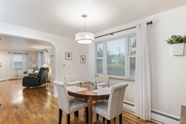 3888 Estes St, Wheat Ridge, CO 80033 - dining area with arched walkways, light wood finished floors, and baseboard heating