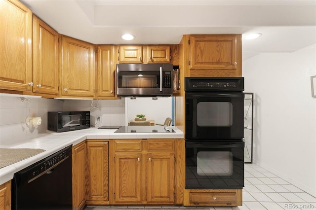 3888 Estes St, Wheat Ridge, CO 80033 - kitchen featuring black appliances, backsplash, light tile patterned floors, recessed lighting, and brown cabinets