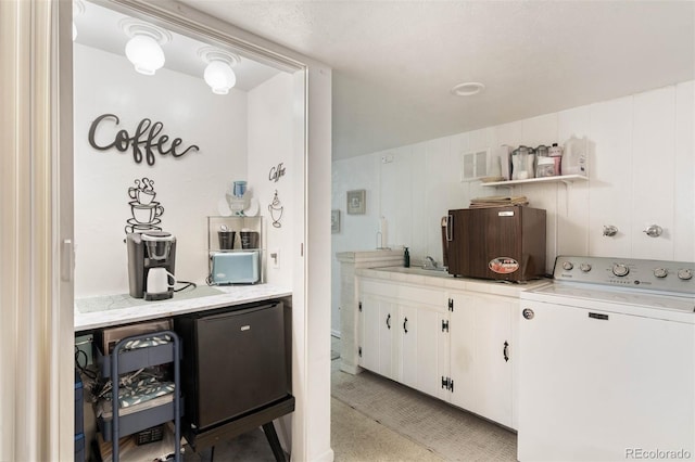 3888 Estes St, Wheat Ridge, CO 80033 - kitchen featuring washer / clothes dryer, light countertops, white cabinets, open shelves, and fridge