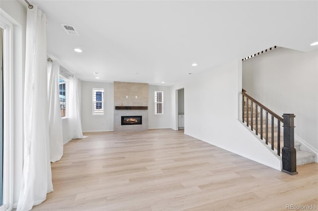 unfurnished living room featuring light wood-style floors, recessed lighting, stairs, a fireplace, and baseboards