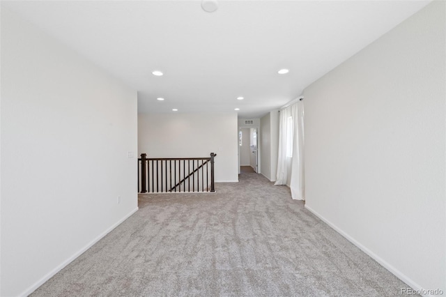 carpeted empty room featuring recessed lighting and baseboards