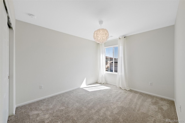 carpeted empty room with baseboards and a smoke detector