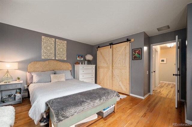 4011 S Ivy Ln, Cherry Hills Village, CO 80111 - bedroom featuring light wood finished floors and a barn door