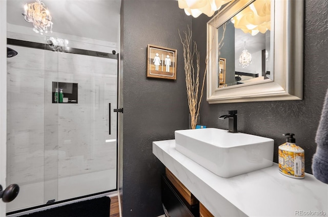 4011 S Ivy Ln, Cherry Hills Village, CO 80111 - bathroom featuring a textured wall, a shower stall, vanity, and a chandelier