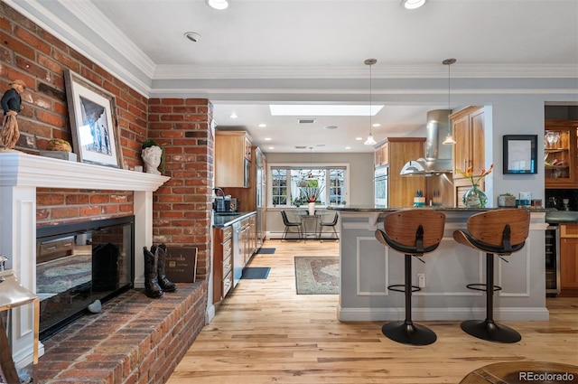 4011 S Ivy Ln, Cherry Hills Village, CO 80111 - kitchen with wall chimney range hood, a kitchen bar, beverage cooler, light wood-style flooring, and a fireplace