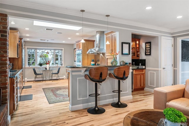 4011 S Ivy Ln, Cherry Hills Village, CO 80111 - kitchen featuring wall chimney range hood, a baseboard heating unit, light wood-style flooring, a kitchen bar, and a peninsula