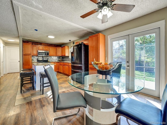 dining room featuring ceiling fan, light wood finished floors, a textured ceiling, french doors, and recessed lighting