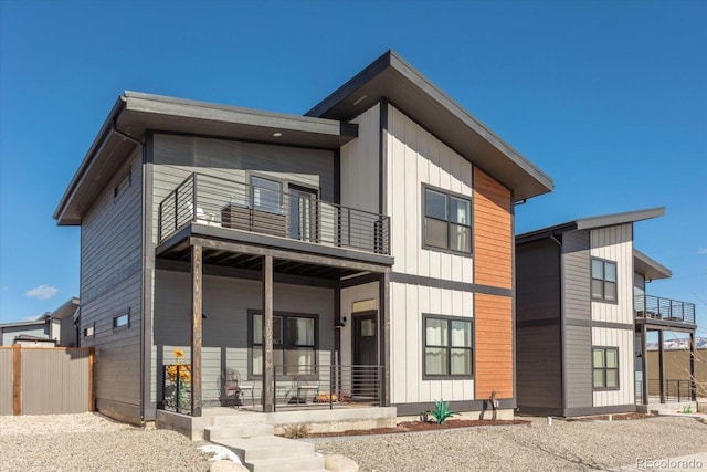 back of property featuring a balcony and covered porch