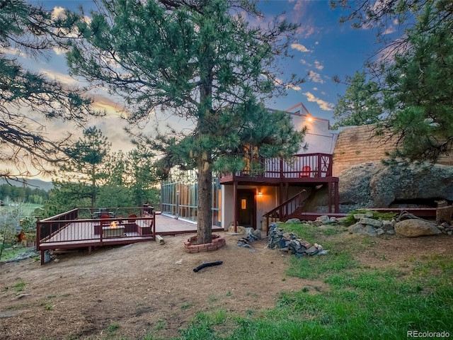8791 Grizzly Way, Evergreen, CO 80439 - back of house at dusk featuring a deck and stairs