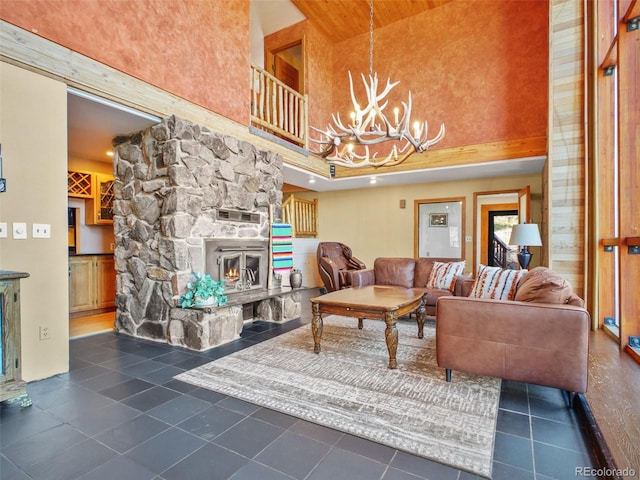 8791 Grizzly Way, Evergreen, CO 80439 - living area with a high ceiling, a chandelier, a stone fireplace, and dark tile patterned floors