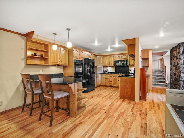 8791 Grizzly Way, Evergreen, CO 80439 - kitchen with black appliances, light wood finished floors, a peninsula, and a sink