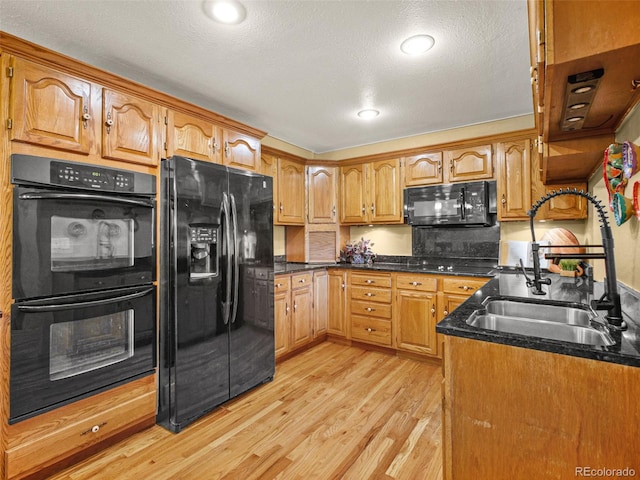 8791 Grizzly Way, Evergreen, CO 80439 - kitchen with black appliances, a sink, light wood finished floors, brown cabinetry, and a textured ceiling
