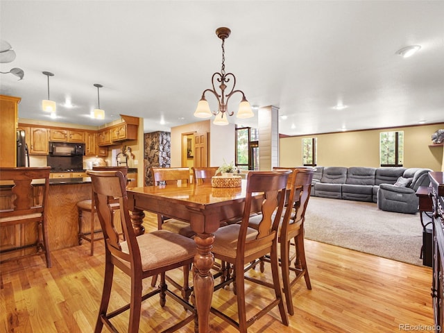 8791 Grizzly Way, Evergreen, CO 80439 - dining room featuring light wood-style floors, a chandelier, and decorative columns
