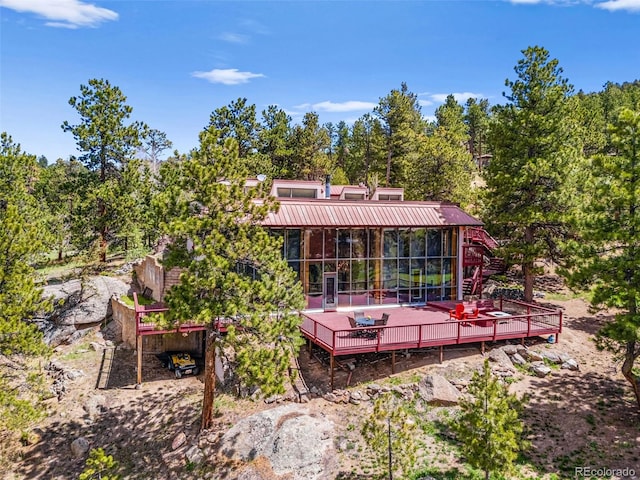 8791 Grizzly Way, Evergreen, CO 80439 - rear view of house featuring a deck, metal roof, and a sunroom
