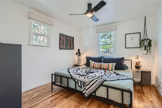 bedroom with ceiling fan, light wood-type flooring, and multiple windows