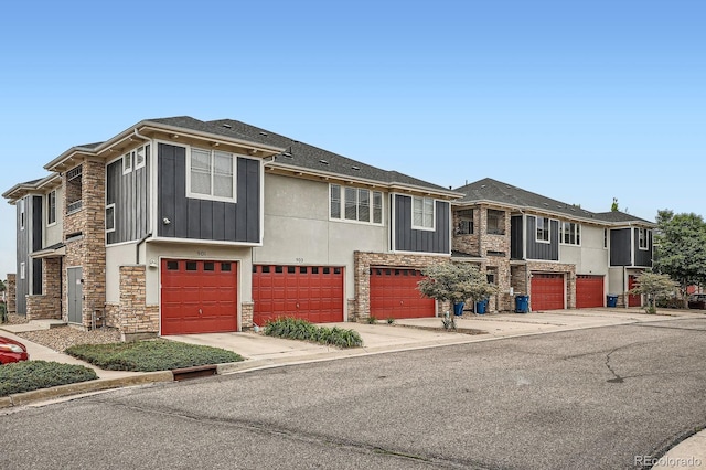 9300 E Florida Ave Unit 906, Denver, CO 80247 - view of front of property featuring stone siding, an attached garage, and driveway