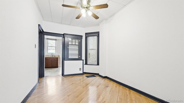 553 N Logan St, Denver, CO 80203 - spare room with light wood-style flooring, baseboards, and a healthy amount of sunlight