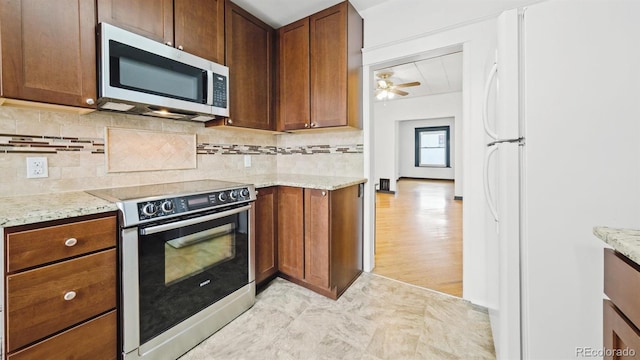 553 N Logan St, Denver, CO 80203 - kitchen with decorative backsplash, stainless steel appliances, light stone counters, and ceiling fan