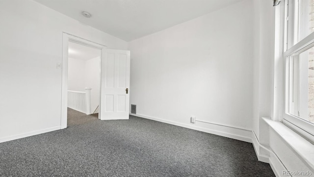553 N Logan St, Denver, CO 80203 - spare room featuring dark colored carpet, baseboards, and visible vents
