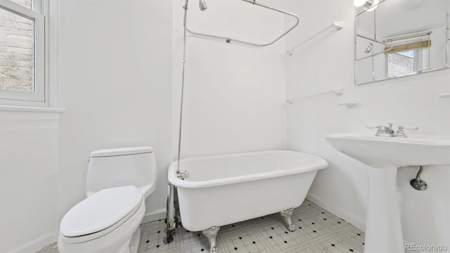 553 N Logan St, Denver, CO 80203 - full bath featuring baseboards, toilet, a freestanding tub, and a sink