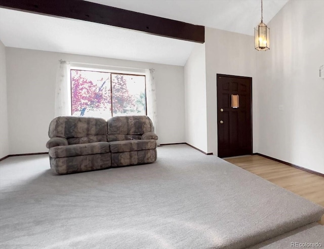 carpeted living room featuring vaulted ceiling with beams and baseboards