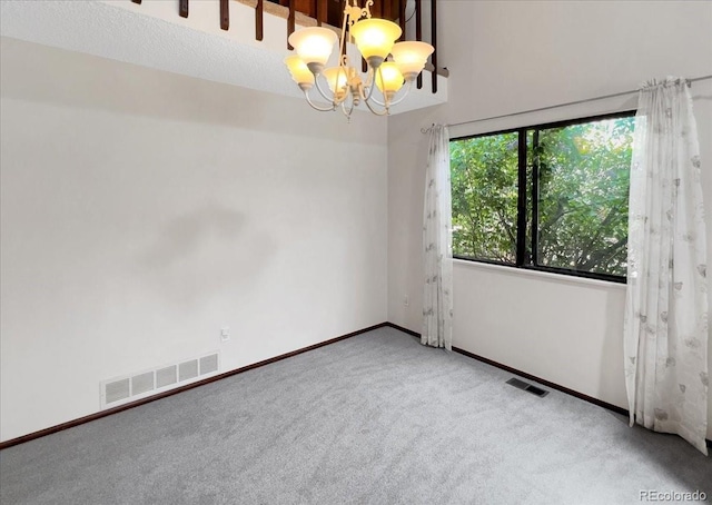 carpeted empty room with baseboards, a chandelier, and visible vents