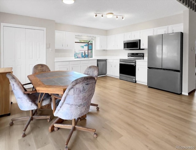 kitchen featuring light countertops, stainless steel appliances, white cabinetry, and light wood-type flooring