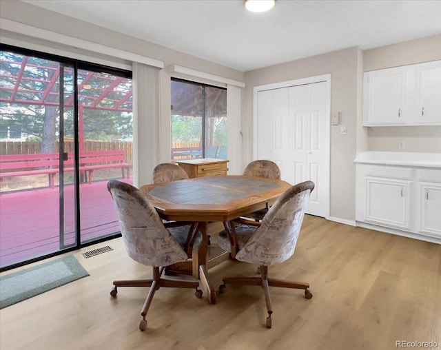 dining area featuring visible vents, light wood finished floors, and baseboards