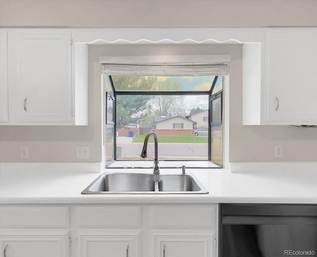 kitchen featuring white cabinets, light countertops, a sink, and dishwasher