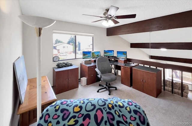 office space featuring lofted ceiling with beams, ceiling fan, light carpet, and a textured ceiling
