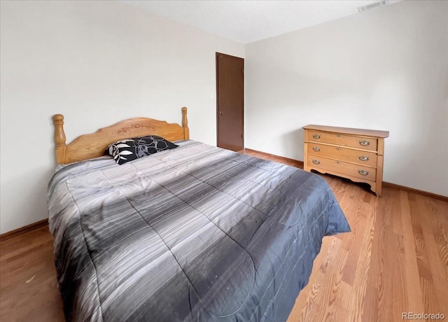 bedroom with baseboards and light wood finished floors
