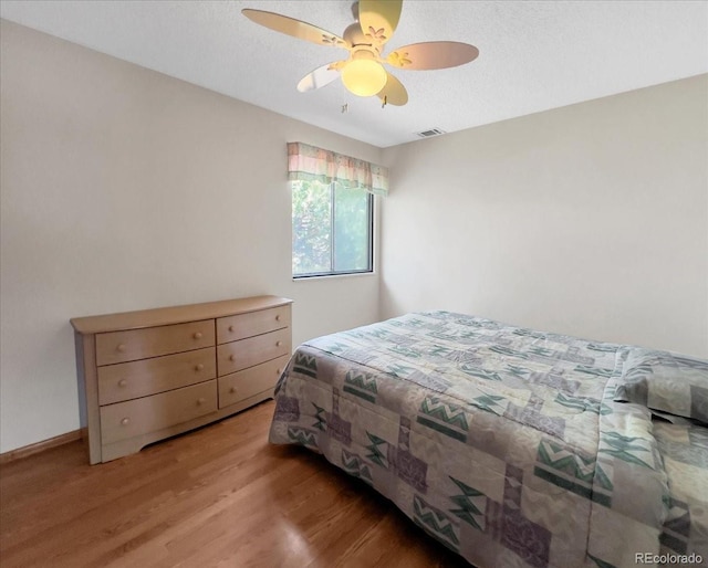 bedroom with ceiling fan, visible vents, and light wood-type flooring