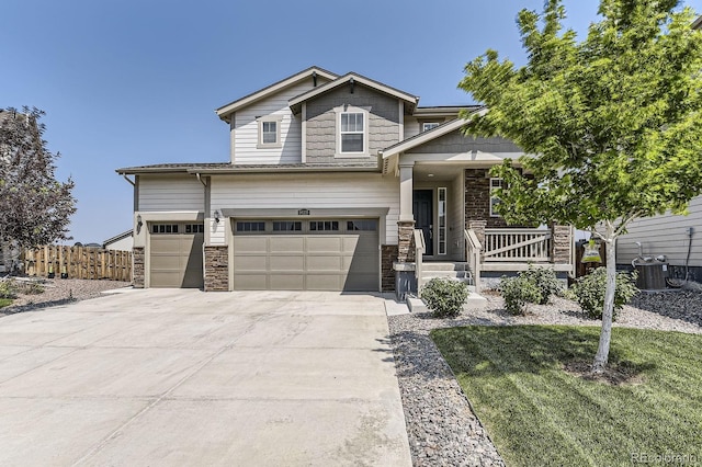 craftsman inspired home with concrete driveway, fence, and covered porch