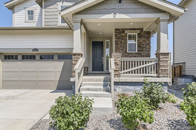 entrance to property featuring stone siding, covered porch, and driveway